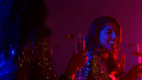 Close-Up-Of-Two-Women-In-Nightclub-Bar-Or-Disco-Dancing-And-Drinking-Alcohol-With-Paper-Confetti-2